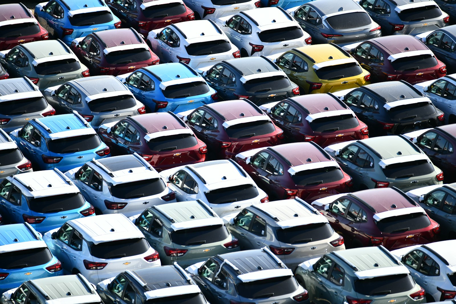 Rows of new cars parked closely together in a lot