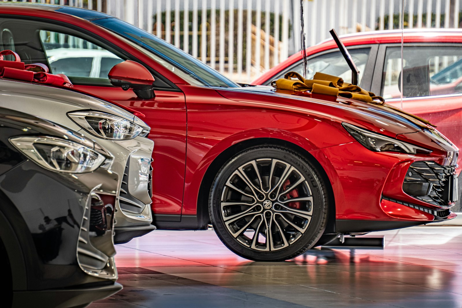 Red and silver cars on display in a showroom