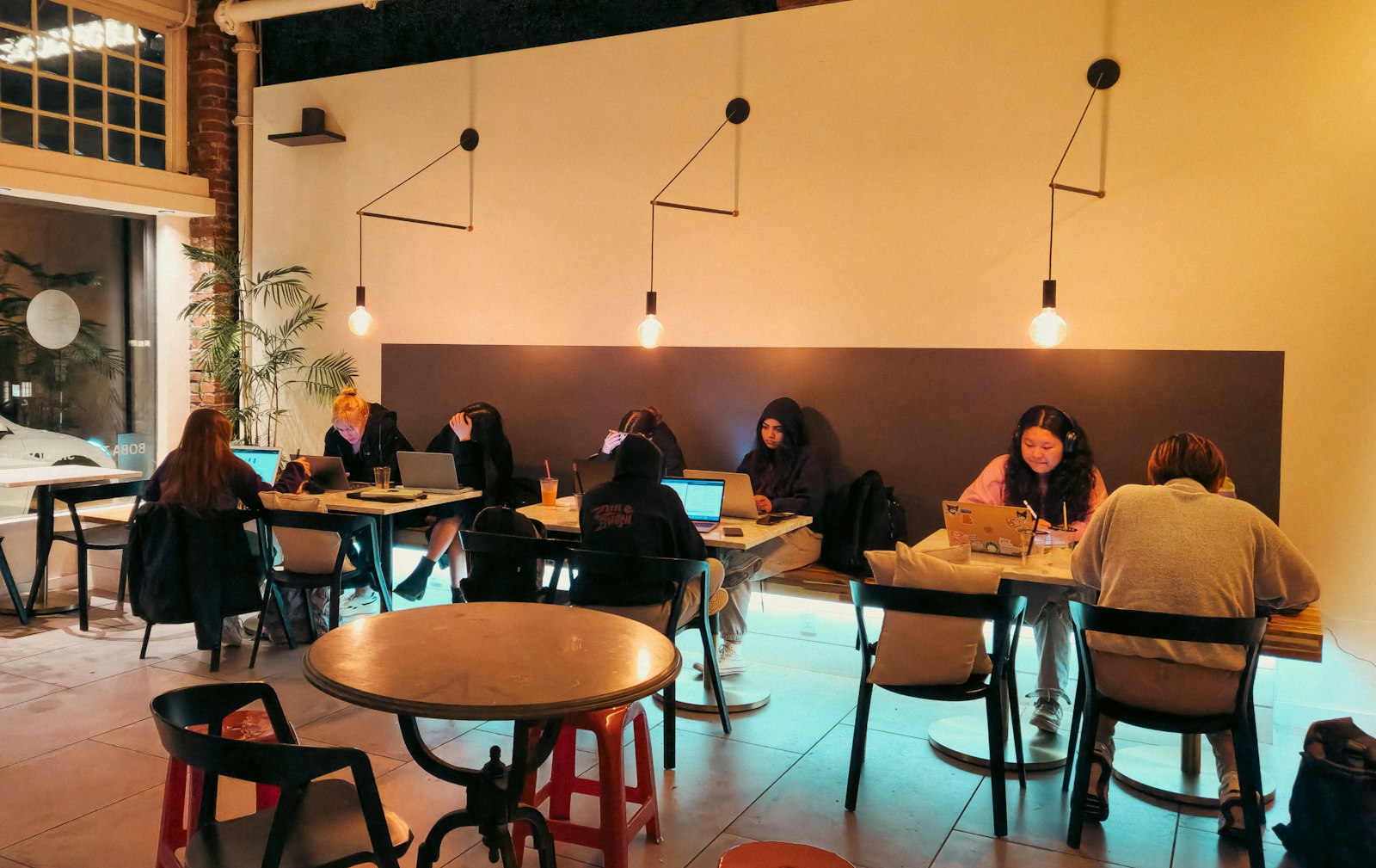 People working on laptops at tables in a café